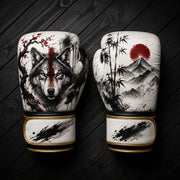 White and black boxing gloves featuring a fierce wolf with red paint stripe, cherry blossoms, bamboo forest, red sun, and mountains ink wash design for combat sports training.