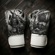 Black and white boxing gloves featuring a Norse Viking god Odin with ravens and wolves, and a Viking longship with runic compass art design for combat sports training.