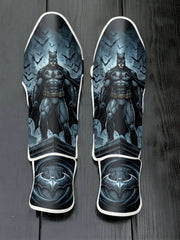 Custom Batman Dark Knight superhero design with rooftop view, swarming bats, rain, and Gotham City metallic bat emblem soccer shin guards displayed on a dark surface.