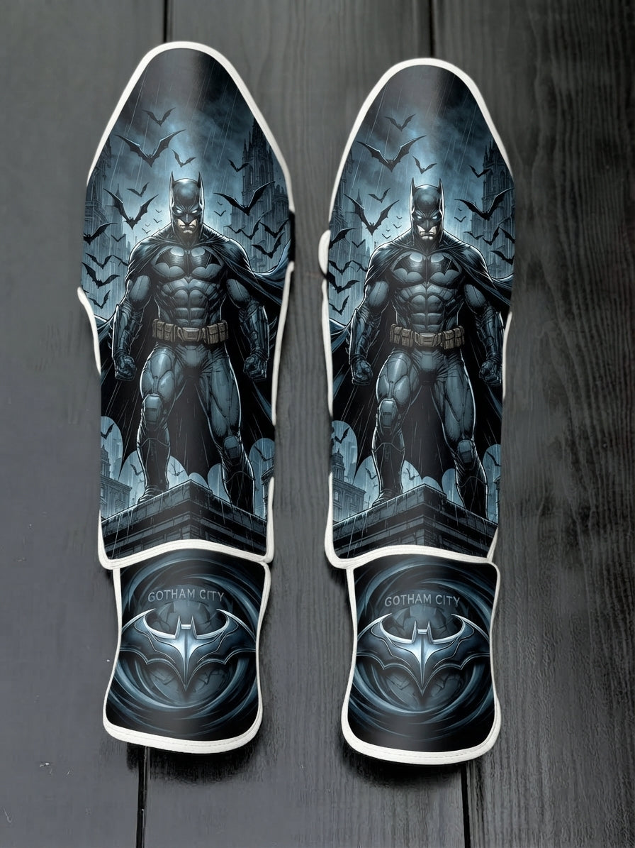Custom Batman Dark Knight superhero design with rooftop view, swarming bats, rain, and Gotham City metallic bat emblem soccer shin guards displayed on a dark surface.