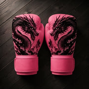 Pink Fiest Gloves boxing gloves featuring a detailed black ink dragon design resting on a dark wooden surface.
