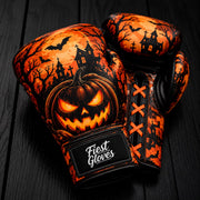 Fiest Gloves Halloween edition boxing gloves featuring a glowing Jack-o'-lantern pumpkin, bats, and haunted house artwork on a dark wooden background.
