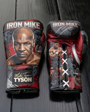Custom black and red leather boxing gloves featuring a realistic portrait of Mike Tyson, 'Iron Mike' lettering, signature wrist patch, and white lace-up closure.