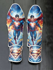 Custom Superman Man of Steel superhero design with flying pose, red cape, 'POW' comic action text, and glowing 'S' shield soccer shin guards displayed on a dark surface.