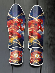 Custom The Flash superhero design with red and yellow suit, Speed Force lightning trails, cosmic background, and lightning bolt emblem soccer shin guards displayed on a dark surface.
